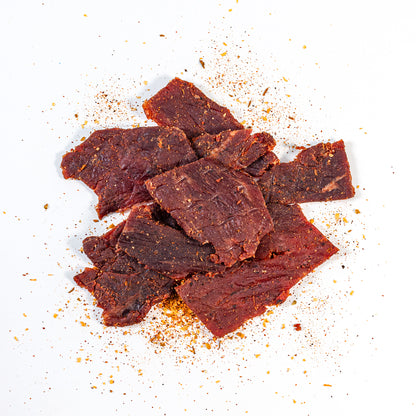 Tender Sedona Sand beef jerky strips seasoned with garlic, herbs and Southwest chiles, showing texture and seasoning granules