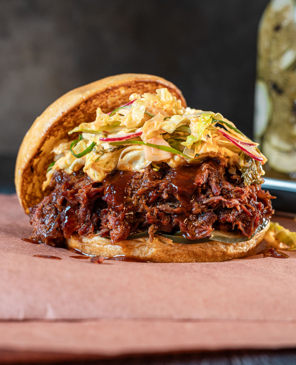 BBQ sandwich with pulled meat and coleslaw on a wooden board